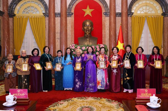 Ph&oacute; Chủ tịch nước V&otilde; Thị &Aacute;nh Xu&acirc;n tặng qu&agrave; lưu niệm cho c&aacute;c nữ đảng vi&ecirc;n ti&ecirc;u biểu Thủ đ&ocirc; (b&agrave; B&ugrave;i Thị An đứng thứ năm từ phải qua). (Ảnh: Hội LHPN H&agrave; Nội)