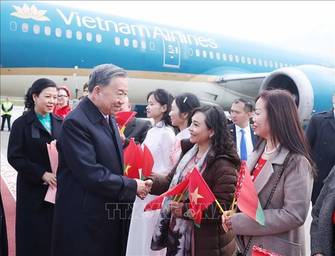 Đại diện cộng đồng người Việt Nam tại Belarus đ&oacute;n Tổng B&iacute; thư T&ocirc; L&acirc;m v&agrave; Phu nh&acirc;n ở s&acirc;n bay quốc tế Minsk. Ảnh: Thống Nhất/TTXVN