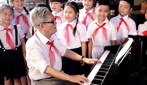 Nhạc sĩ Phong Nh&atilde; đang đ&aacute;nh đ&agrave;n cho c&aacute;c Đội vi&ecirc;n Thiếu ni&ecirc;n Tiền phong h&aacute;t. (Ảnh: N.V.To&agrave;n)