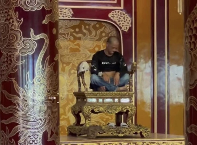 Hồ Văn Phương T&acirc;m vượt qua h&agrave;ng r&agrave;o bảo vệ, leo l&ecirc;n ngai v&agrave;ng Triều Nguyễn ngồi.
