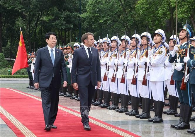 Chủ tịch nước Lương Cường v&agrave; Tổng thống Ph&aacute;p Emmanuel Macron duyệt Đội danh dự Qu&acirc;n đội nh&acirc;n d&acirc;n Việt Nam. Ảnh: L&acirc;m Kh&aacute;nh/TTXVN