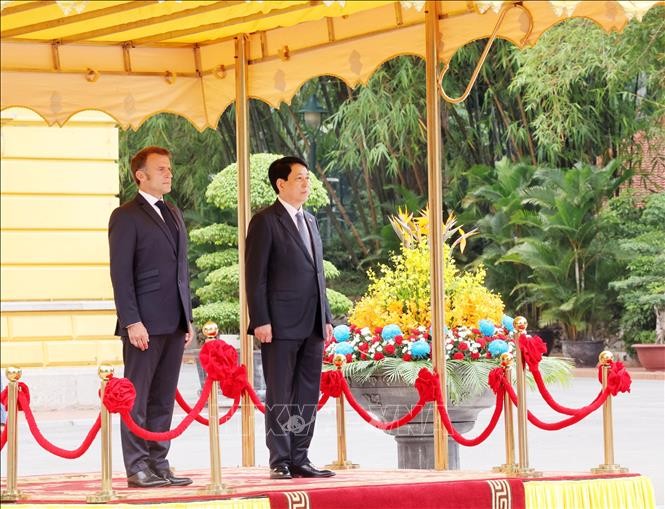 Chủ tịch nước Lương Cường v&agrave; Tổng thống Ph&aacute;p Emmanuel Macron nghe qu&acirc;n nhạc cử Quốc thiều hai nước. Ảnh: L&acirc;m Kh&aacute;nh/TTXVN