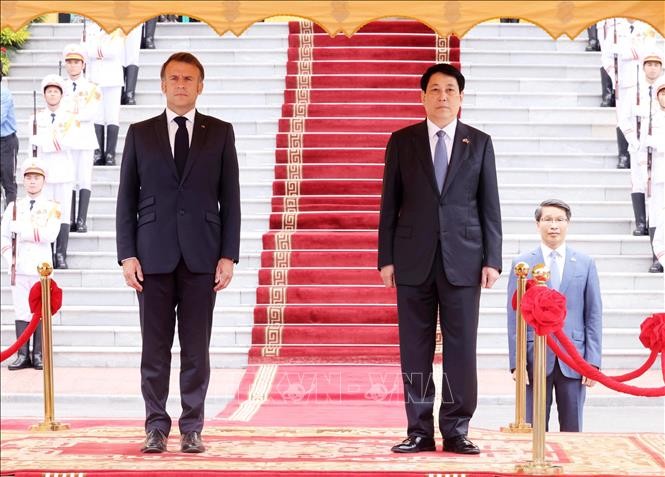 Chủ tịch nước Lương Cường v&agrave; Tổng thống Ph&aacute;p Emmanuel Macron nghe qu&acirc;n nhạc cử Quốc thiều hai nước. Ảnh: L&acirc;m Kh&aacute;nh/TTXVN