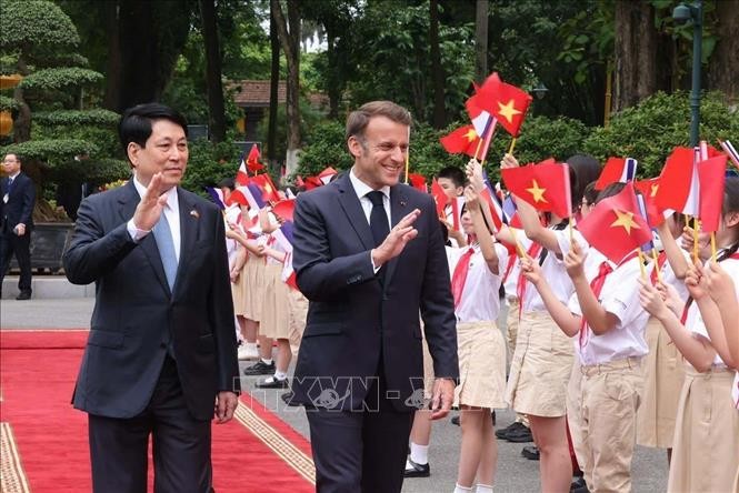 Chủ tịch nước Lương Cường v&agrave; Tổng thống Ph&aacute;p Emmanuel Macron với thiếu nhi Thủ đ&ocirc; H&agrave; Nội. Ảnh: L&acirc;m Kh&aacute;nh/TTXVN