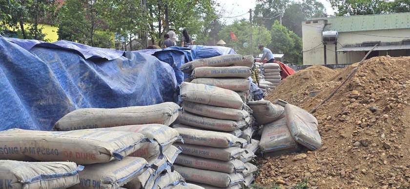 H&agrave;ng trăm tấn xi măng đ&ocirc;ng cứng v&igrave; kh&ocirc;ng được bảo quản tốt được tập kết tại s&acirc;n vận động x&atilde; Lộc Y&ecirc;n. Ảnh: Hữu Anh