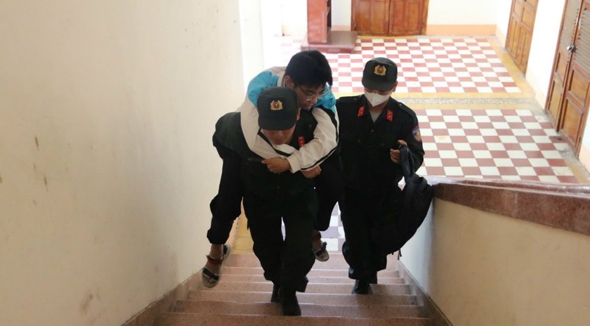 B&ecirc;n trong Trường Quốc học Quy Nhơn, c&aacute;c sĩ quan cảnh s&aacute;t thuộc Trung đo&agrave;n Cảnh s&aacute;t Cơ động Nam Trung Bộ tiếp tục c&otilde;ng th&iacute; sinh Đ.V.P l&ecirc;n cầu thang để đảm bảo em đến được ph&ograve;ng thi của m&igrave;nh.