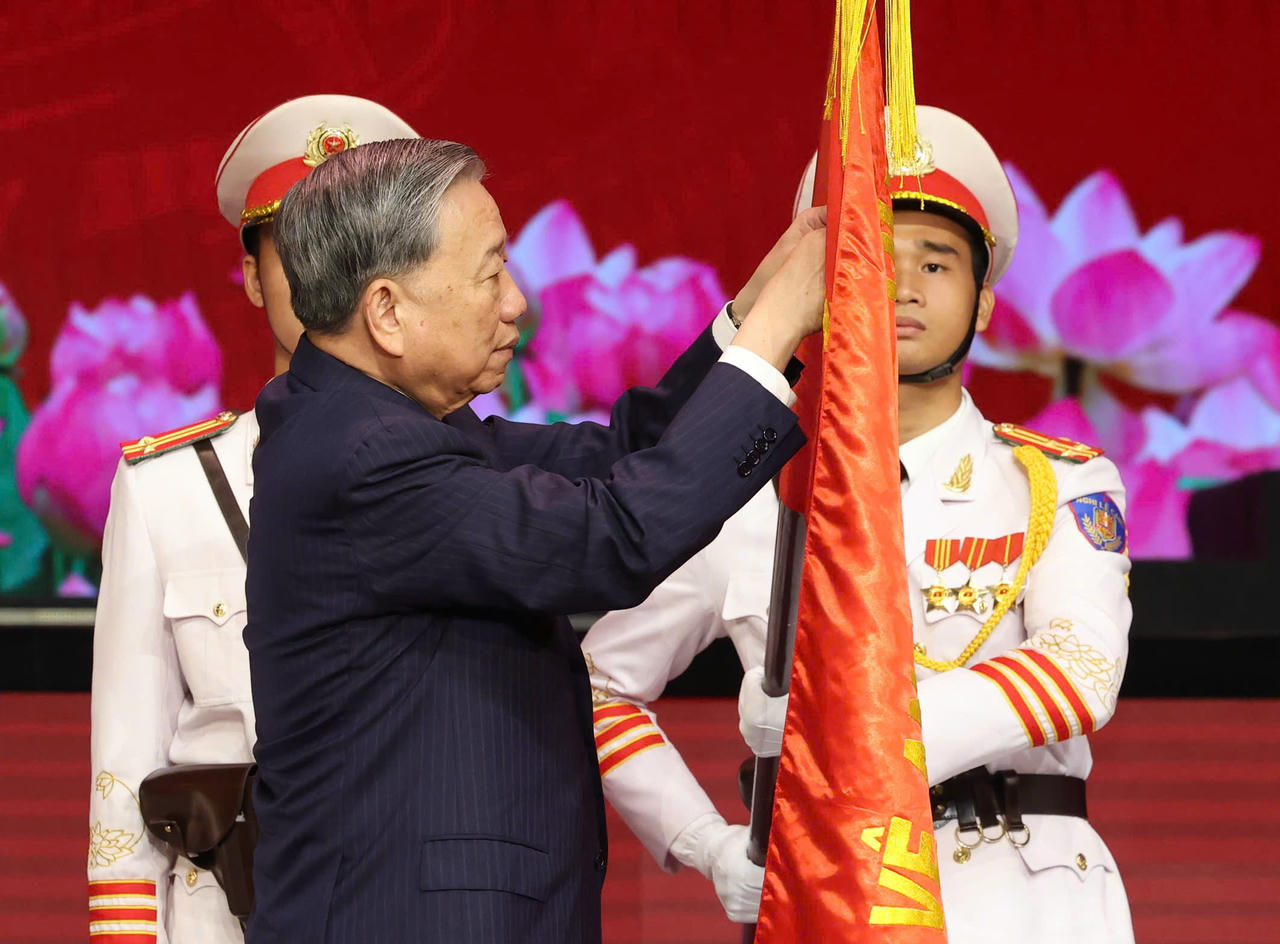 Tổng B&iacute; thư gắn Hu&acirc;n chương l&ecirc;n l&aacute; cờ truyền thống của lực lượng C&ocirc;ng an.
