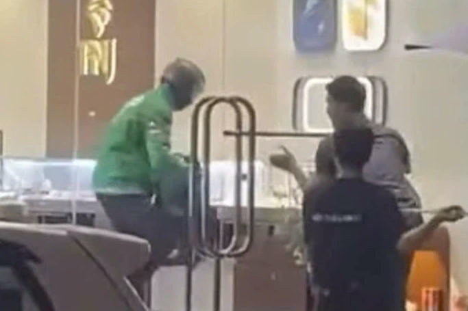 Đối tượng mặc &aacute;o Grab x&ocirc;ng v&agrave;o tiệm v&agrave;ng cướp t&agrave;i sản.