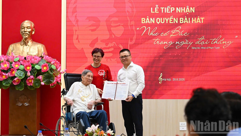 Tổng Bi&ecirc;n tập L&ecirc; Quốc Minh nhận bản thảo b&agrave;i h&aacute;t Như c&oacute; B&aacute;c trong ng&agrave;y đại thắng c&oacute; chữ k&yacute; đề tặng của nhạc sĩ Phạm Tuy&ecirc;n. (Ảnh: TH&Agrave;NH ĐẠT)