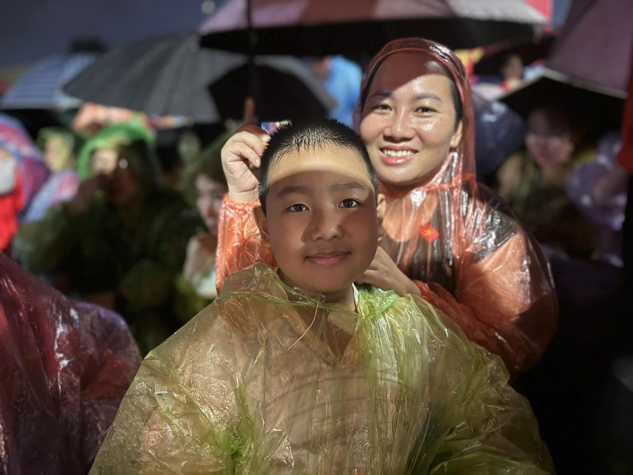 B&eacute; Phương Nguy&ecirc;n (8 tuổi, Ph&ugrave;ng Quang, H&agrave; Nội) c&ugrave;ng mẹ ngồi chờ xem diễu binh.