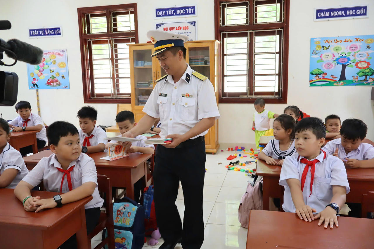 L&atilde;nh đạo, chỉ huy đảo Đ&aacute; T&acirc;y trao s&aacute;ch vở cho c&aacute;c em nhỏ, tiếp th&ecirc;m niềm vui trong ng&agrave;y tựu trường.