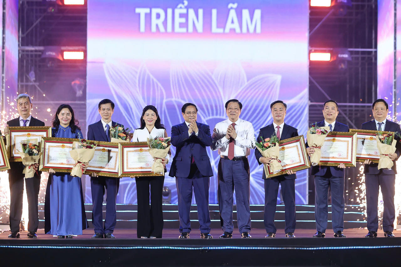Thay mặt Bộ X&acirc;y dựng, Thứ trưởng Nguyễn Việt H&ugrave;ng (thứ ba từ phải sang) nhận Bằng khen của Thủ tướng Ch&iacute;nh phủ biểu dương đơn vị c&oacute; th&agrave;nh t&iacute;ch xuất sắc trong c&ocirc;ng t&aacute;c tổ chức v&agrave; tham gia Triển l&atilde;m.