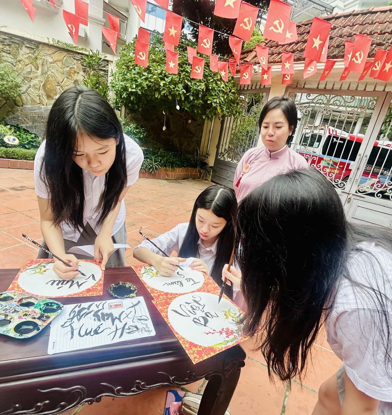 Chị Nguyễn Thị Thu Trang hướng dẫn học sinh viết thư ph&aacute;p theo những c&acirc;u thơ của nh&agrave; thơ Tố Hữu (Ảnh: Th&ugrave;y Dương).