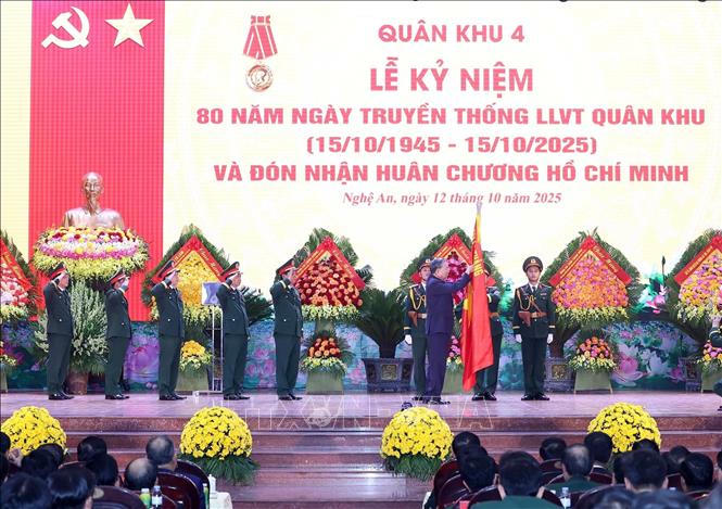 Tổng B&iacute; thư T&ocirc; L&acirc;m gắn Hu&acirc;n chương Hồ Ch&iacute; Minh l&ecirc;n l&aacute; cờ truyền thống của Qu&acirc;n khu 4.&nbsp; Ảnh: Thống Nhất/TTXVN