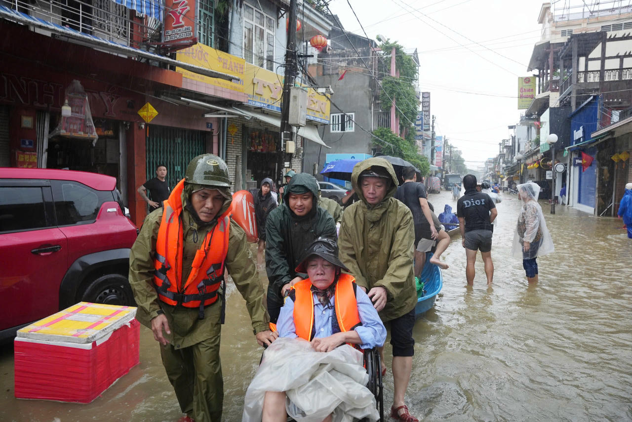 Huế ứng phó trận lũ lịch sử Ông Phan Thiên Định (ngoài cùng bên phải) lội lũ giúp bệnh nhân.