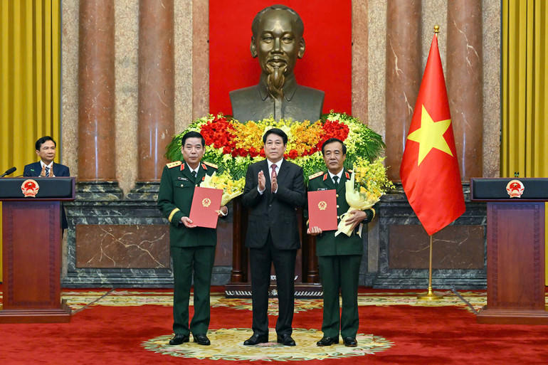 Chủ tịch nước Lương Cường trao quyết định v&agrave; tặng hoa ch&uacute;c mừng &ocirc;ng Nguyễn Văn Gấu v&agrave; &ocirc;ng L&ecirc; Đức Th&aacute;i. Ảnh: nhandan.vn