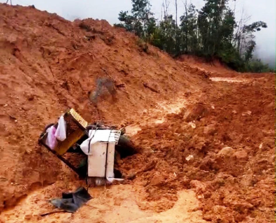 Chiếc xe m&aacute;y bị v&ugrave;i lấp sau vụ sạt lở.