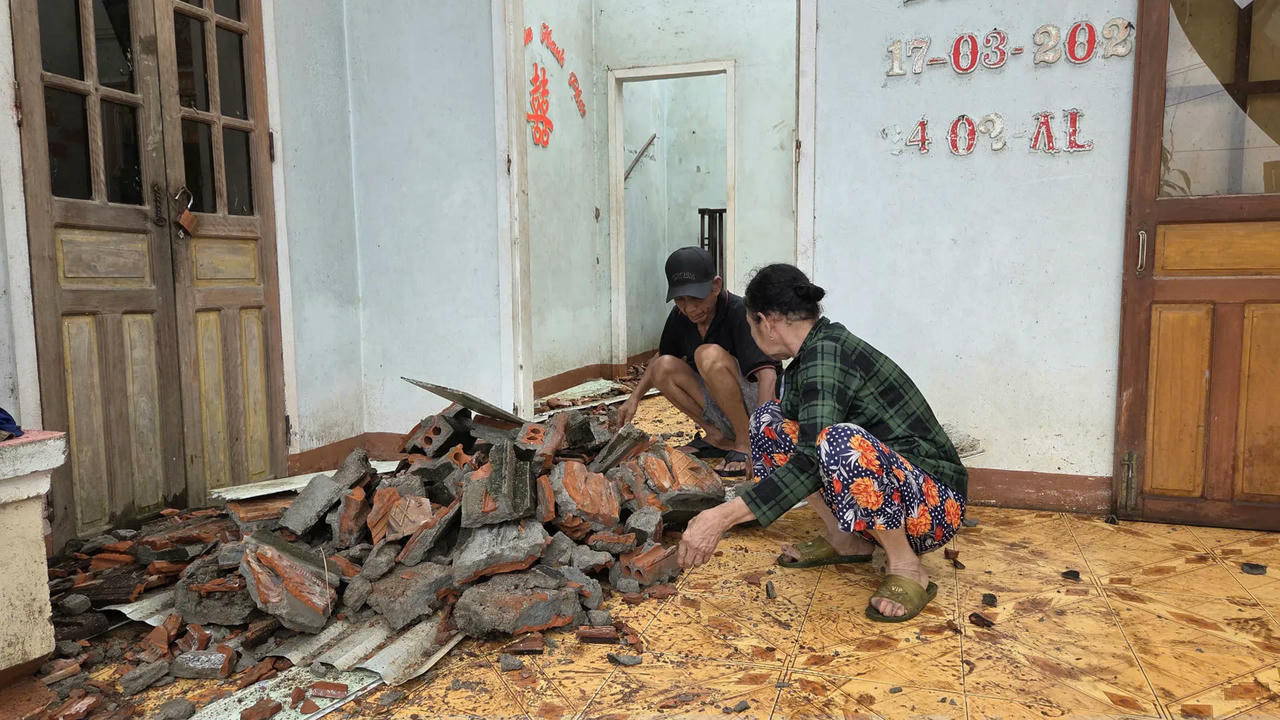 Người d&acirc;n thu dọn c&aacute;c mảnh ng&oacute;i, xi măng vỡ n&aacute;t.
