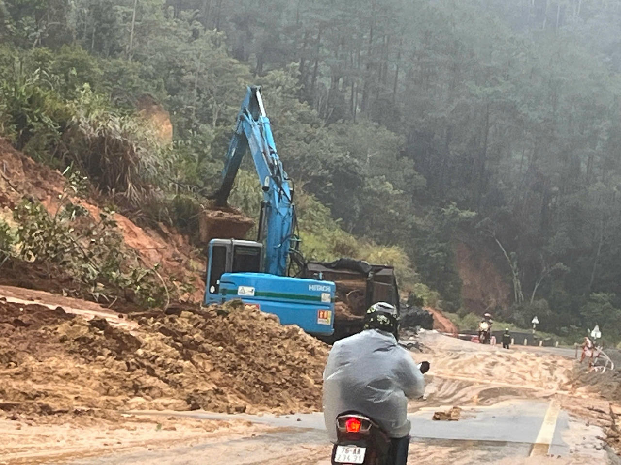 Một điểm sạt lở taluy dương lớn tr&ecirc;n QL24 qua x&atilde; Măng Đen khiến giao th&ocirc;ng bị chia cắt ho&agrave;n to&agrave;n, lực lượng chức năng tiếp cận hiện trường trong điều kiện thời tiết xấu.