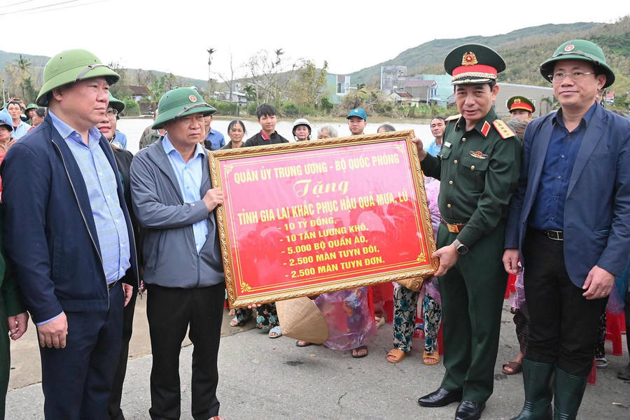 Đại tướng Phan Văn Giang trao bảng tượng trưng gửi tặng phần hỗ trợ từ Qu&acirc;n ủy Trung ương, Bộ Quốc Ph&ograve;ng đến đồng b&agrave;o Gia Lai. Ảnh: B&aacute;o Gia Lai.