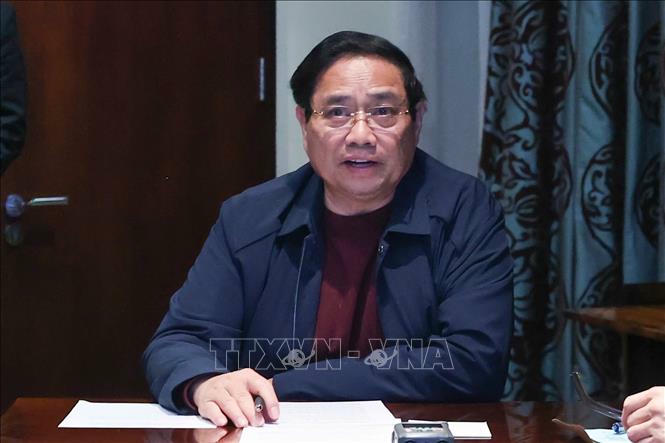 Thủ tướng Phạm Minh Ch&iacute;nh chủ tr&igrave; họp trực tuyến từ Nam Phi, chỉ đạo khắc phục hậu quả mưa lũ. Ảnh: Dương Giang/TTXVN