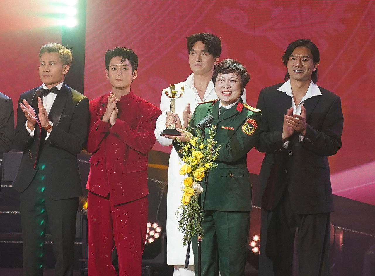 Đạo diễn Đặng Th&aacute;i Huyền đại diện đo&agrave;n phim &ldquo;Mưa đỏ&rdquo; nhận giải B&ocirc;ng sen v&agrave;ng. Ảnh: BTC