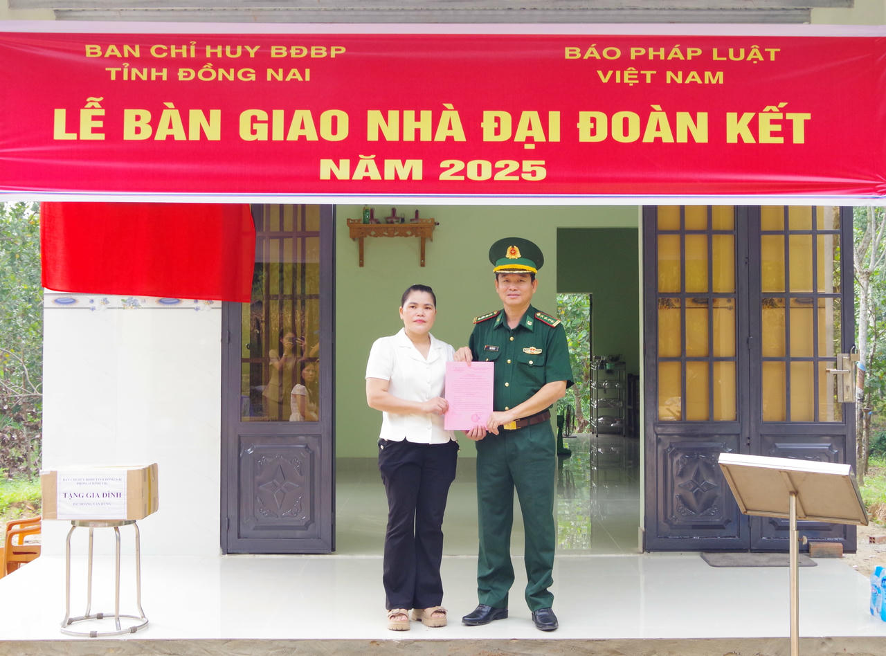 B&agrave; M&ugrave;ng Thị Thu - mẹ của Hạ sĩ Ho&agrave;ng Văn H&ugrave;ng nhận Quyết định b&agrave;n giao nh&agrave; Đại đo&agrave;n kết (ảnh: Cao Thi)