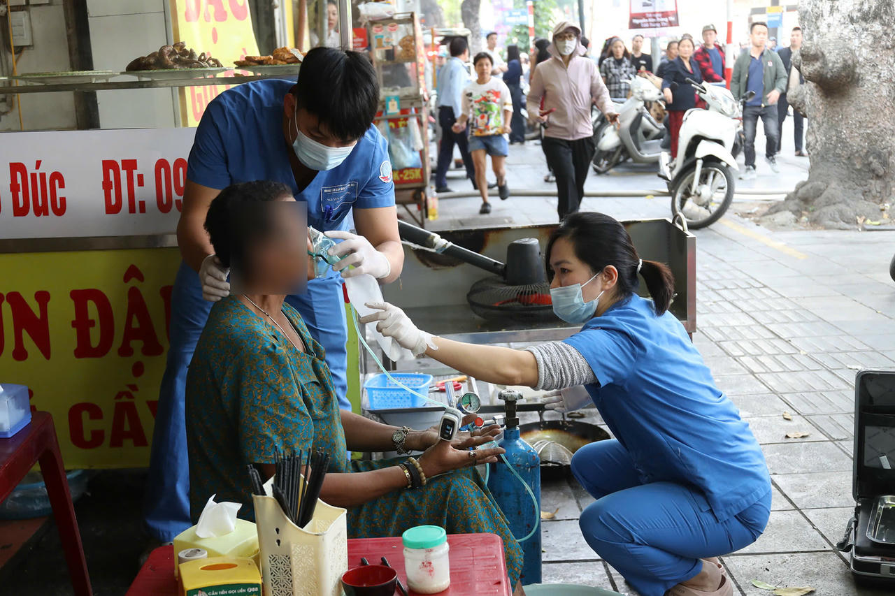 Một người phụ nữ được lực lượng y tế chăm s&oacute;c sức khỏe. (Ảnh: Vietnamnet).