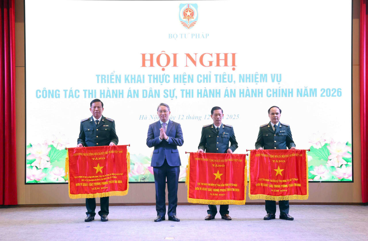 Bộ trưởng Bộ Tư ph&aacute;p Nguyễn Hải Ninh đ&atilde; tặng Cờ thi đua của Ch&iacute;nh phủ cho 3 tập thể. (Ảnh: Phương Mai)