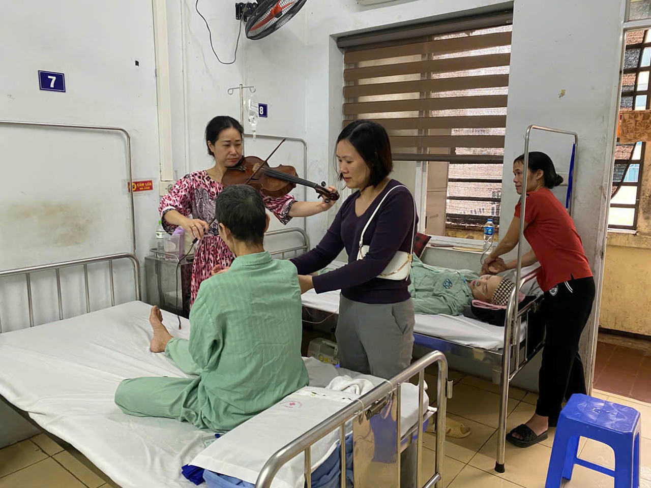 Nghệ sĩ viola Quốc tế Nguyệt Thu tặng bản nhạc &ecirc;m dịu d&agrave;nh cho bệnh nh&acirc;n ung thư giai đoạn cuối. (Ảnh: PV)