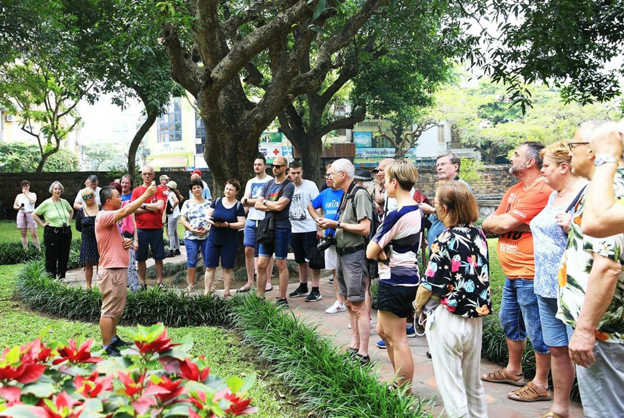 Hướng dẫn du kh&aacute;ch quốc tế tham quan Văn Miếu - Quốc Tử Gi&aacute;m. (Ảnh: Nguyễn Quang)