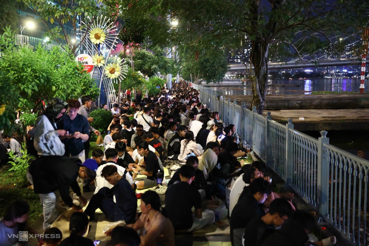 Người d&acirc;n ngồi giữ chỗ ven s&ocirc;ng S&agrave;i G&ograve;n chờ xem ph&aacute;o hoa. Ảnh: Quỳnh Trần - VNExpress