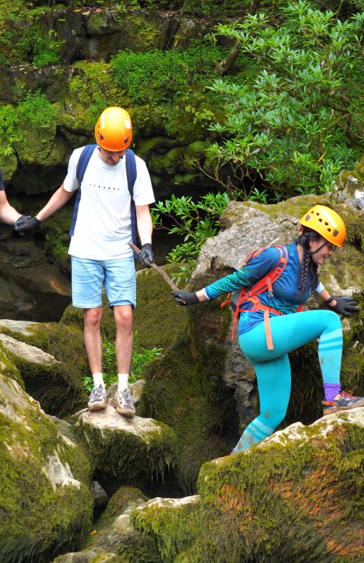 Nữ hướng dẫn vi&ecirc;n cẩn thận hỗ trợ kh&aacute;ch băng qua suối. Ảnh: Jungle Boss