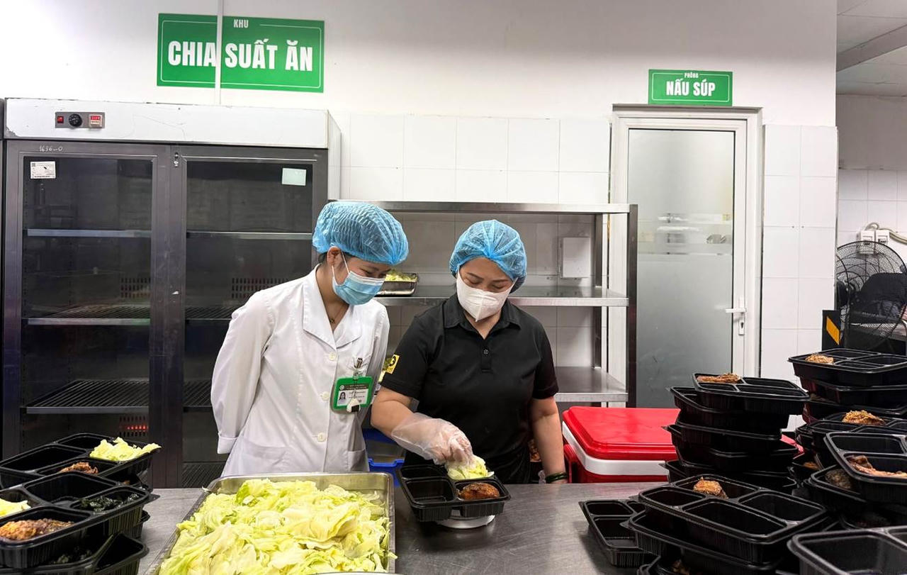 C&aacute;c nh&acirc;n vi&ecirc;n y tế tại Bệnh viện Bạch Mai tiếp nhận suất ăn bệnh l&yacute; tại Khoa l&acirc;m s&agrave;ng.