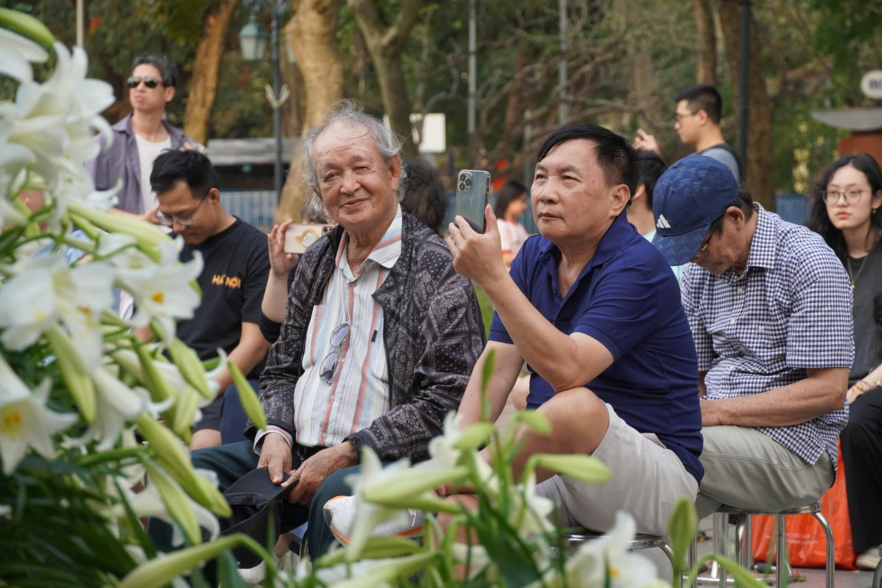 Kh&aacute;n giả h&agrave;o hứng đ&oacute;n nhận chương tr&igrave;nh trong sắc trắng của hoa loa k&egrave;n, sự trầm mặc của kiến tr&uacute;c Nh&agrave; B&aacute;t Gi&aacute;c v&agrave; nhịp sống của phố phường H&agrave; Nội.