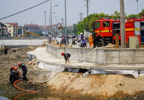 Lực lượng chức năng huy động c&aacute;c nguồn nước sẵn c&oacute; từ s&ocirc;ng Cụt để dập lửa.