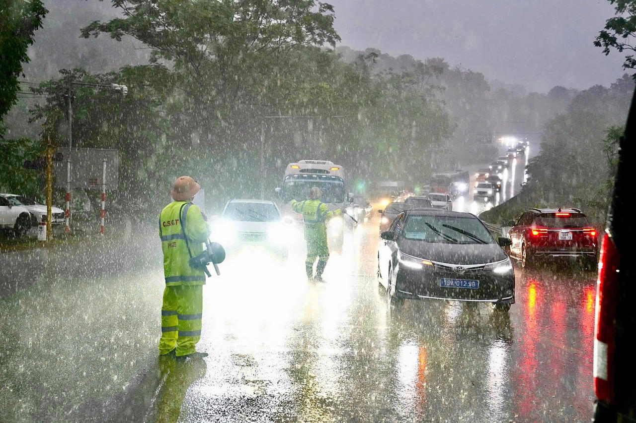 Dưới cơn mưa nặng hạt, c&aacute;c c&aacute;n bộ, chiến sĩ&nbsp; vẫn ki&ecirc;n tr&igrave; điều tiết từng d&ograve;ng xe. Ảnh: C&ocirc;ng an tỉnh Ph&uacute; Thọ&nbsp;