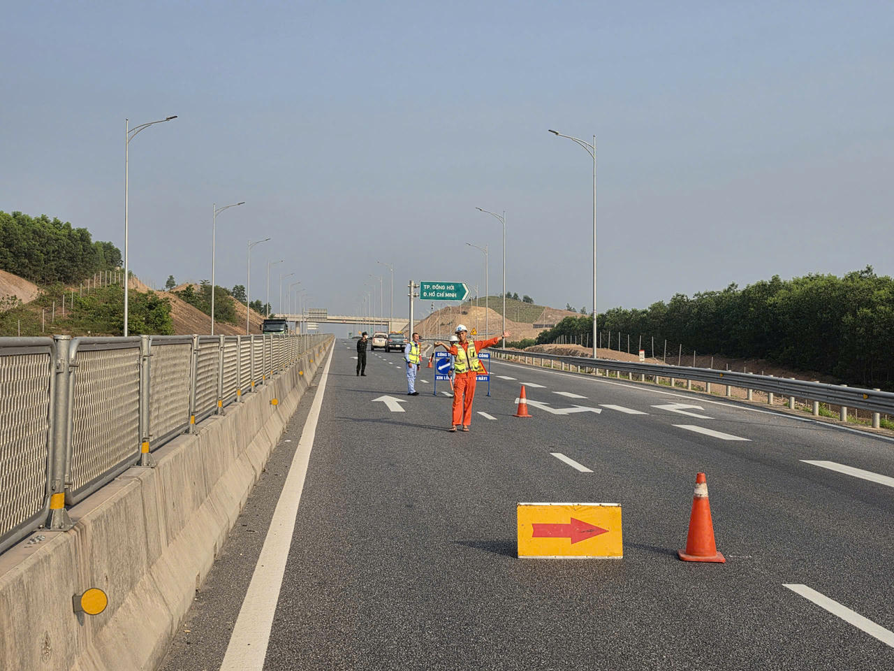 Lực lượng chức năng v&agrave; c&ocirc;ng nh&acirc;n điều tiết giao th&ocirc;ng, ph&acirc;n luồng phương tiện tr&ecirc;n cao tốc Vũng &Aacute;ng - Cam Lộ trong thời gian tạm đ&oacute;ng từng đoạn để phục vụ thi c&ocirc;ng lắp đặt hệ thống.
