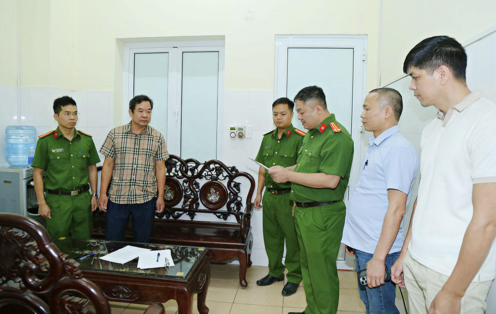 C&ocirc;ng an tỉnh Bắc Ninh kh&aacute;m x&eacute;t nơi l&agrave;m việc của Ho&agrave;ng Văn Huấn (&aacute;o kẻ).