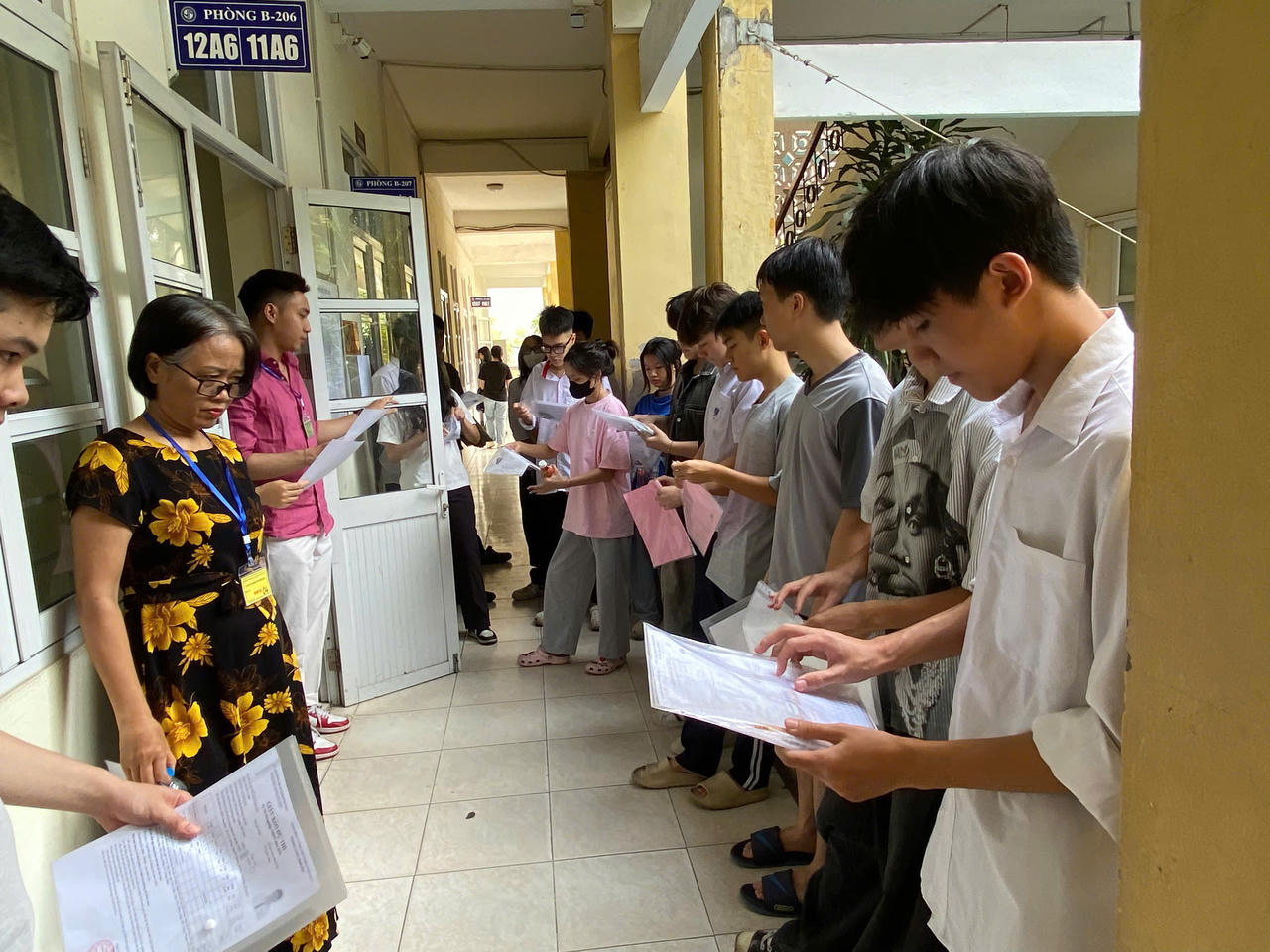 Th&iacute; sinh đang kiểm tra lại giấy tờ trước khi gi&aacute;m thị gọi v&agrave;o ph&ograve;ng thi. (Ảnh: PV)