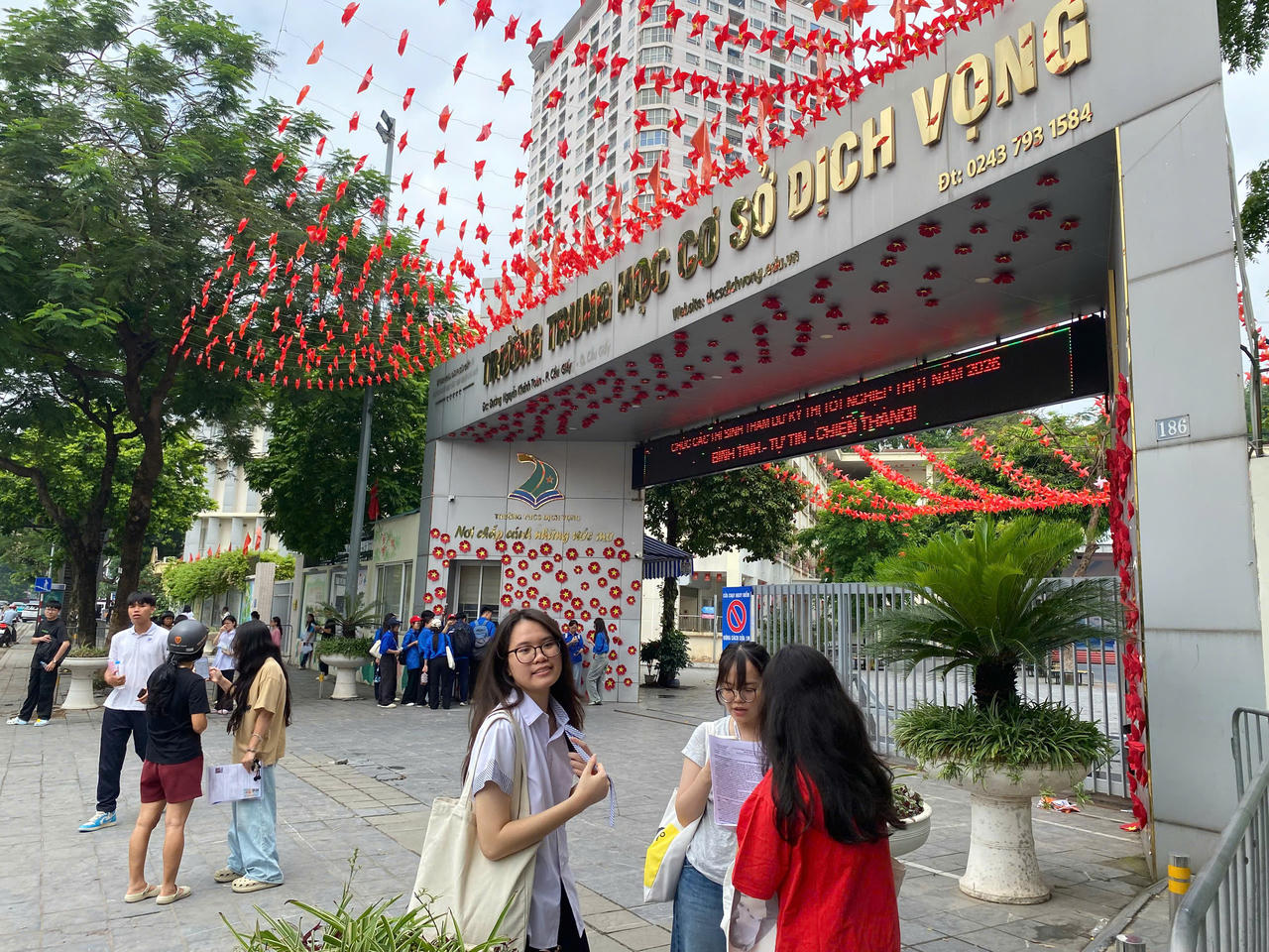 Điểm thi THCS Dịch Vọng c&ograve;n l&aacute;c đ&aacute;c một v&agrave;i th&iacute; sinh đang đứng trao đổi về b&agrave;i thi v&agrave; đợi phụ huynh tới đ&oacute;n. (Ảnh: PV)