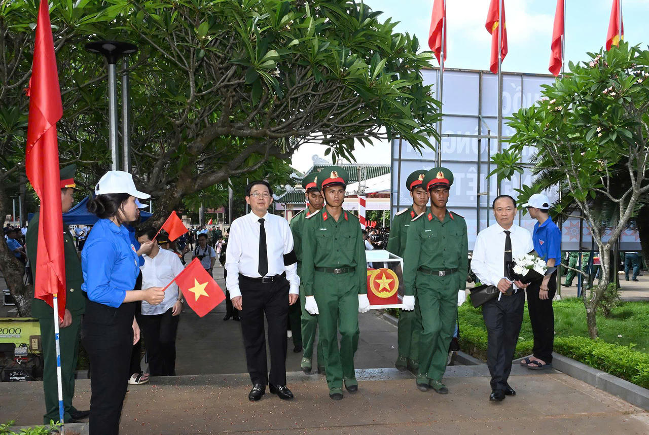 Ph&oacute; Thủ tướng Hồ Quốc Dũng c&ugrave;ng l&atilde;nh đạo địa phương v&agrave; lực lượng chức năng đưa h&agrave;i cốt liệt sĩ về nơi an t&aacute;ng.
