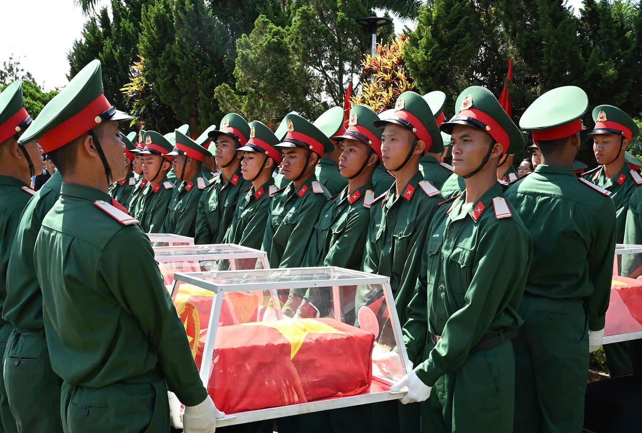 Lực lượng chức năng thực hiện nghi thức an t&aacute;ng c&aacute;c h&agrave;i cốt liệt sĩ.