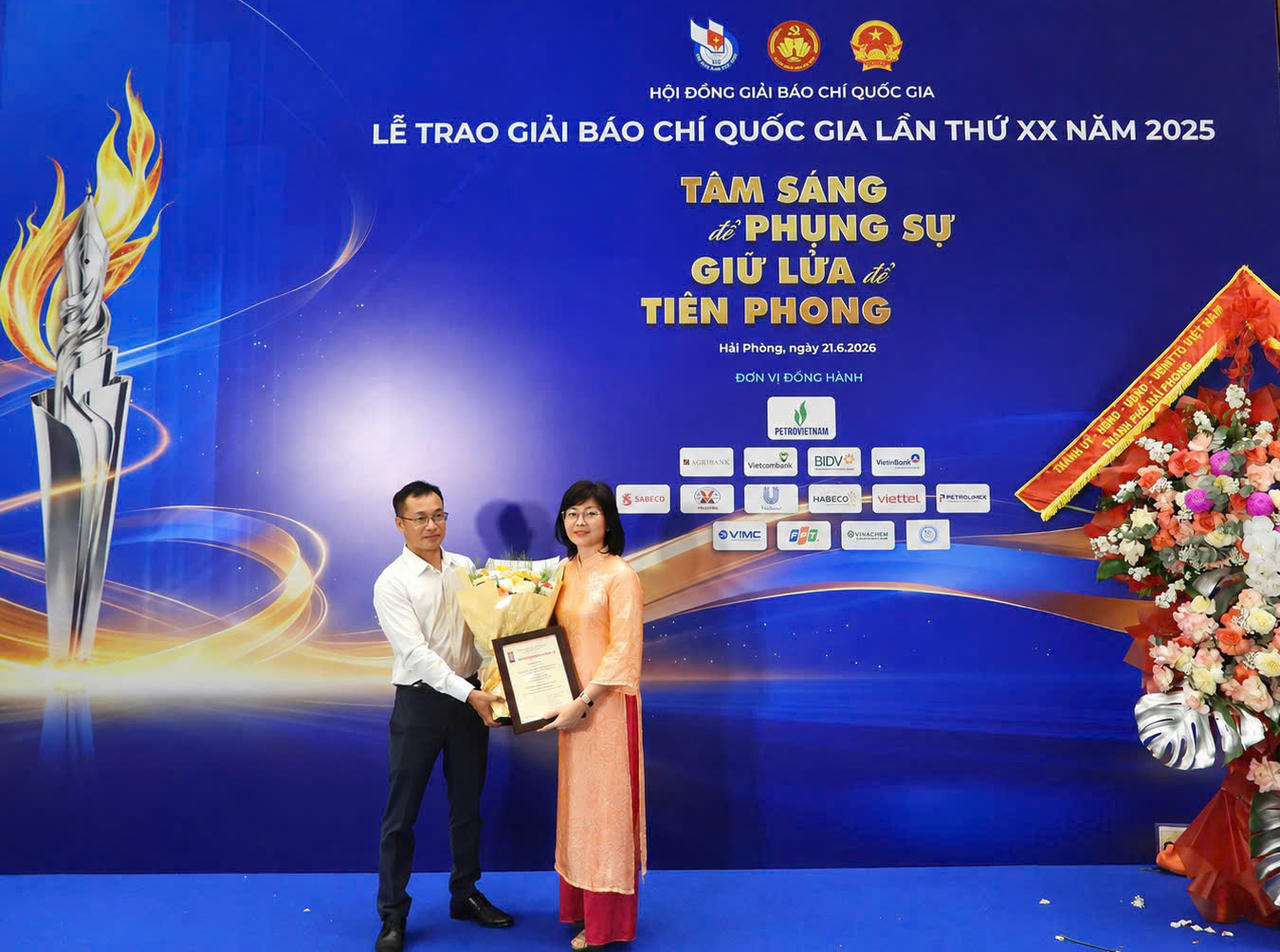 Nh&agrave; b&aacute;o Trần Ngọc H&agrave; - Ph&oacute; Tổng bi&ecirc;n tập, đại diện l&atilde;nh đạo Ban bi&ecirc;n tập B&aacute;o Ph&aacute;p luật Việt Nam tặng hoa Nh&agrave; b&aacute;o Lương Thị V&acirc;n Anh - t&aacute;c giả loạt b&agrave;i gi&agrave;nh giải Khuyến kh&iacute;ch.