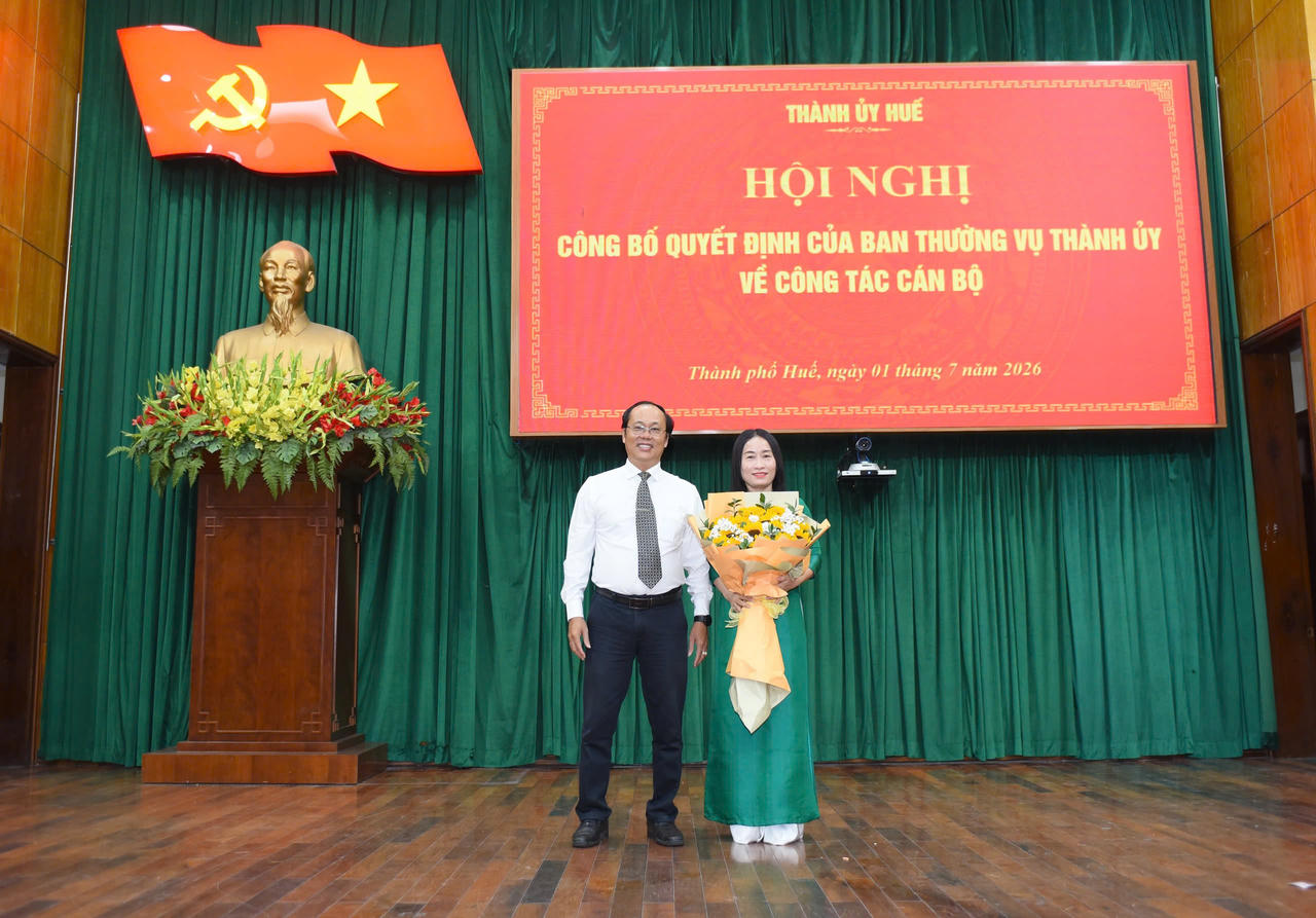 B&agrave; Ch&acirc;u nhận hoa ch&uacute;c mừng từ &ocirc;ng Ho&agrave;ng Đăng Khoa (T&acirc;n Hiệu trưởng Trường Ch&iacute;nh trị Nguyễn Ch&iacute; Thanh)