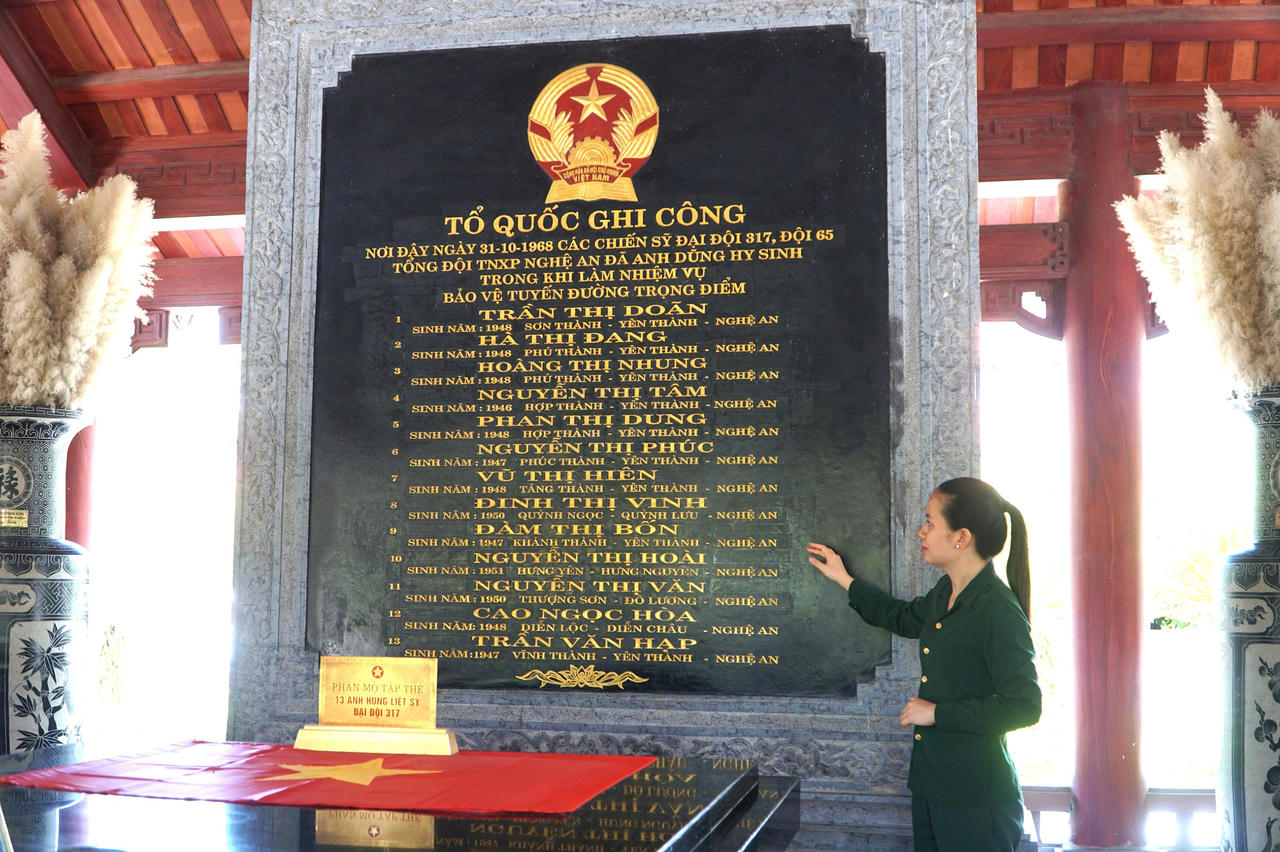 &nbsp;Phần mộ tập thể  của 13 Anh h&ugrave;ng liệt sĩ  Đại đội 317 (ảnh phải). Ảnh: Tuyết Lan