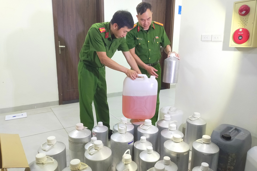 Những can hương liệu, nước hoa giả được c&aacute;c đối tượng d&ugrave;ng để sản xuất, sang chiết nước hoa thương hiệu giả. (Ảnh: Bộ C&ocirc;ng an)