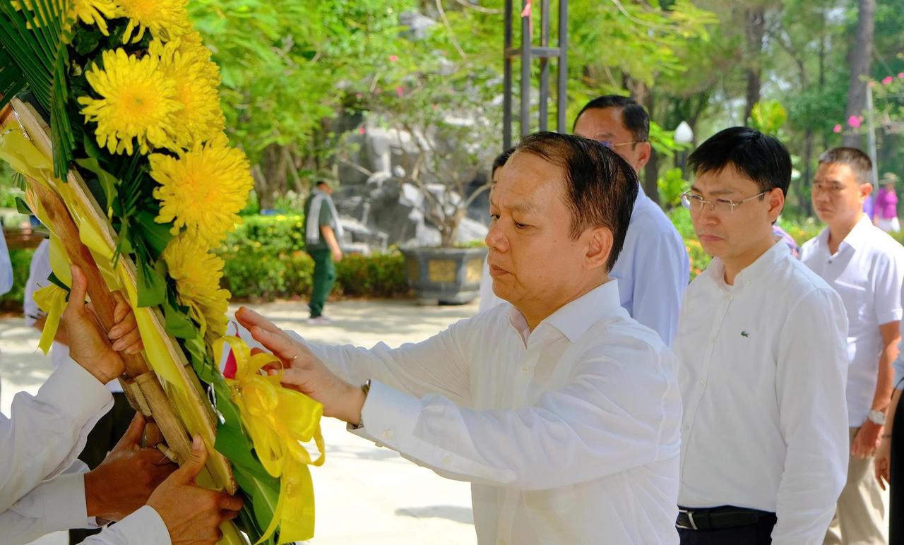 Bộ trưởng chỉnh lại v&ograve;ng hoa tưởng niệm tại Nghĩa trang Liệt sĩ Quốc gia Trường Sơn, thể hiện l&ograve;ng th&agrave;nh k&iacute;nh, tri &acirc;n đối với c&aacute;c Anh h&ugrave;ng liệt sĩ đ&atilde; hy sinh v&igrave; độc lập, tự do của Tổ quốc.