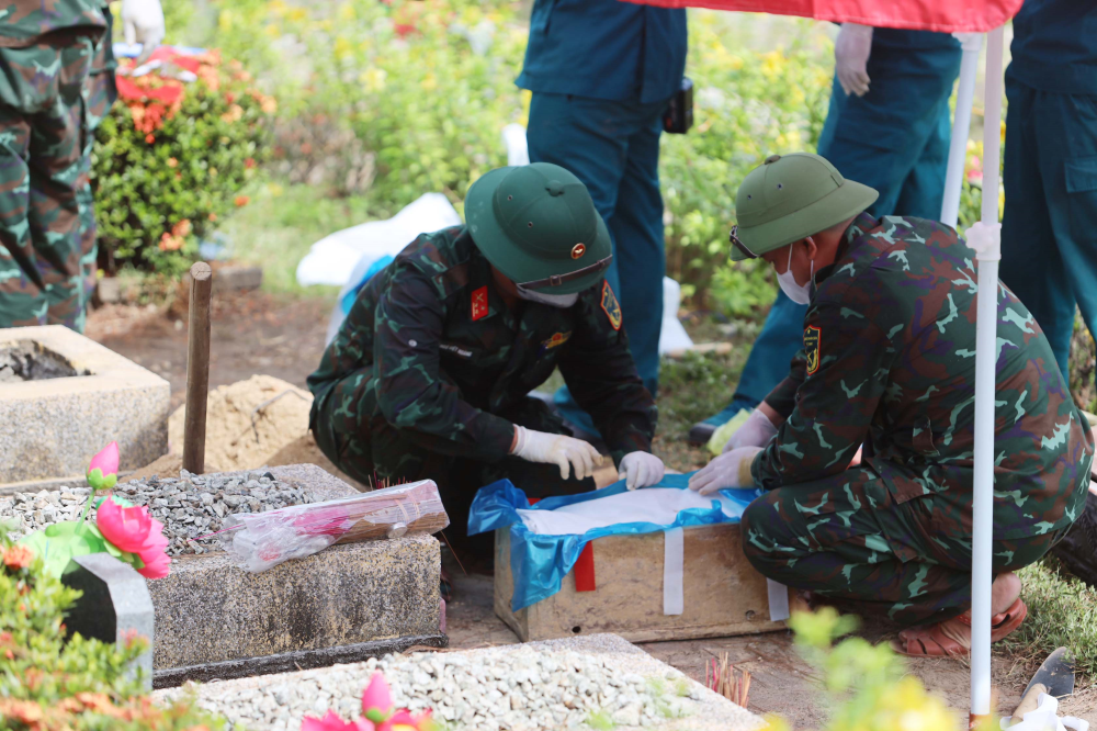 C&aacute;c lực lượng thực hiện c&aacute;c thủ tục khai quật phần mộ để phục vụ cho việc lấy mẫu sinh phẩm. (Ảnh: Quang Đạo)