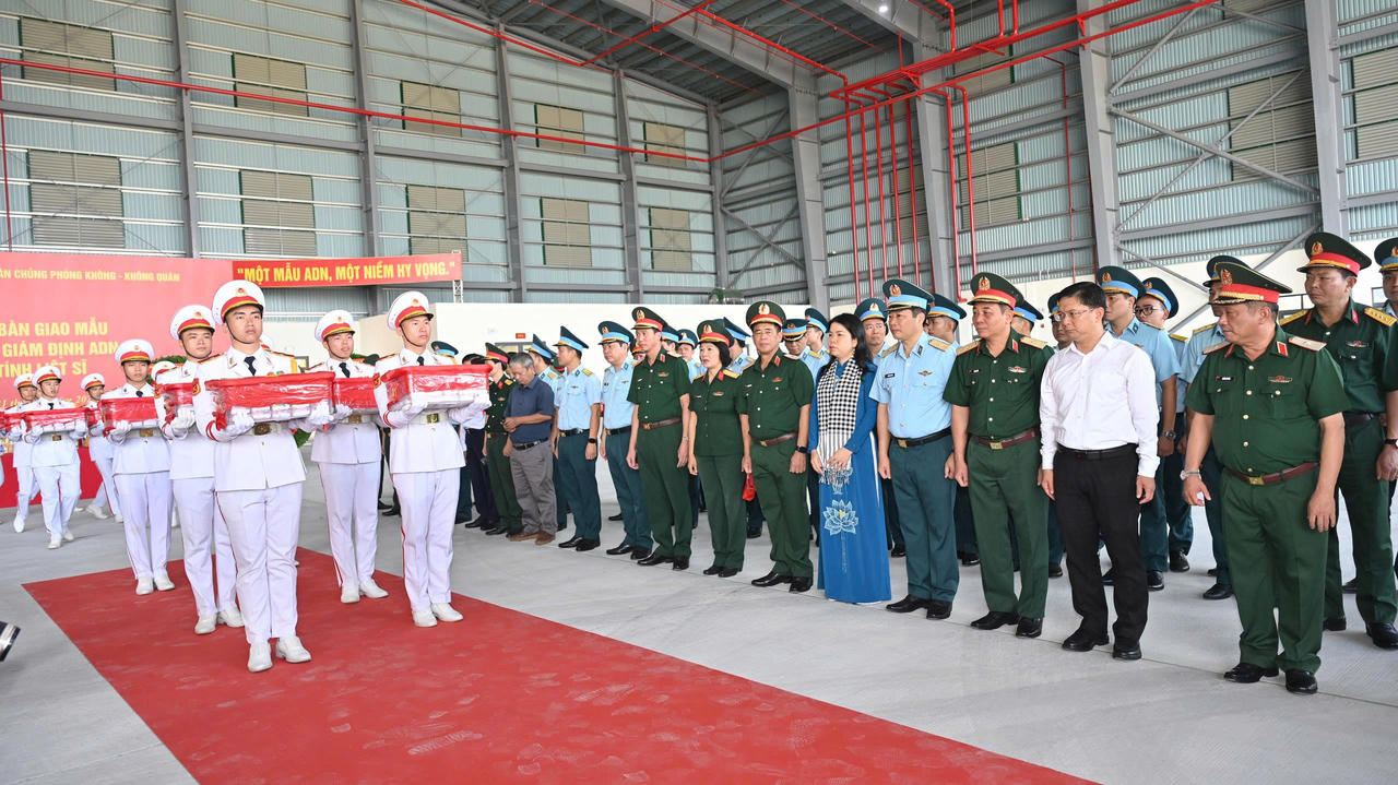 C&aacute;c đại biểu thực hiện Nghi thức đưa mẫu sinh phẩm h&agrave;i cốt c&aacute;c liệt sĩ l&ecirc;n m&aacute;y bay qu&acirc;n sự. (Ảnh: Xu&acirc;n Sang)